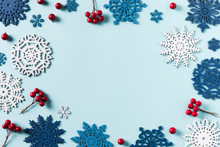 Niebieskie tło, Śnieżynki i jarzębina otaczające krawędzie obrazki, klimat Bożonarodzeniowy